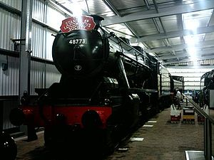 A striking black heritage steam locomotive displayed indoors at the Highley Engine House museum.