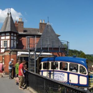 The historic upper station building of the Bridgnorth Cliff Railway with a blue funicular carriage waiting for boarding passengers.